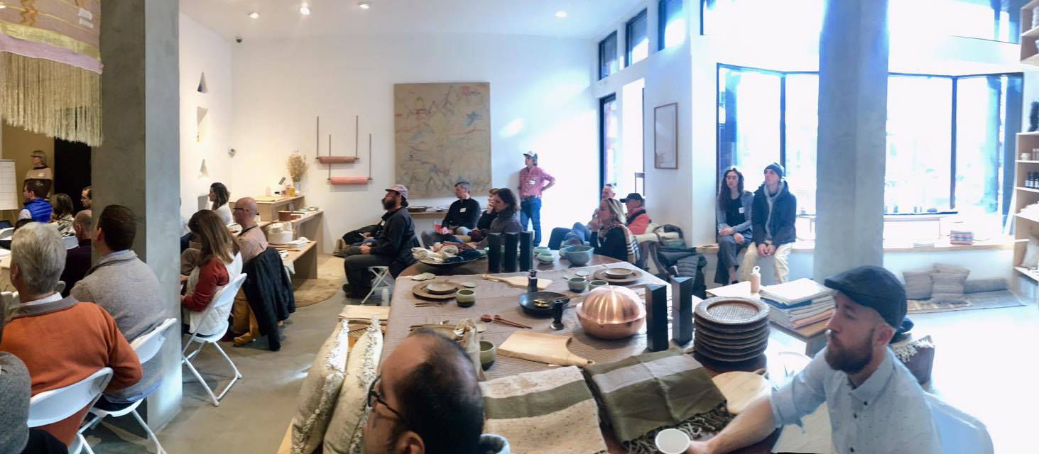 A room of people seated in chairs and around a long table at an Aspen Entrepreneurs gathering, listening to a speaker